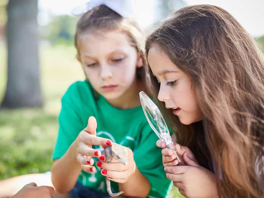 Two girls inspecting a reptile